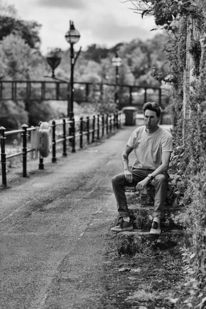 istock Man in his 30s sitting on old steps near a bridge 1396824170