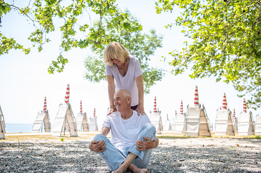 Minimal waist up portrait of modern senior couple embracing against white background and looking at each other