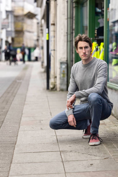 istock Man in his 30s squatting in a pedestrian zone 1396824367