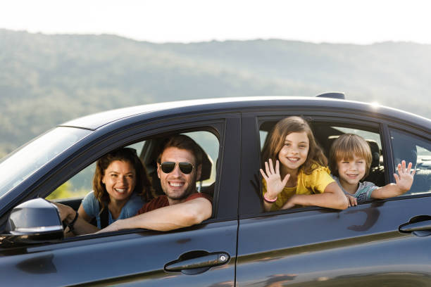 istock Happy parents and their kids going on a trip by car. 1396824944