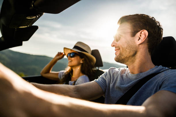 istock Happy couple going on a road trip by convertible car. 1396825899