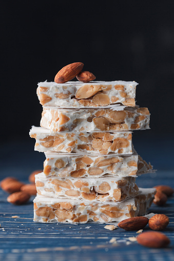 Almond turron dessert slices with nuts on a blue table