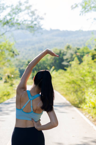 istock Asian women stretch before exercising for good health. Horizontal image while stretching in an outdoor park. A female runner warms up for an evening run and jogging. 1396827089