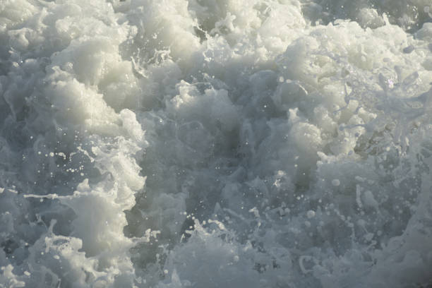 istock White foam in sea waves at sunset 1396827223