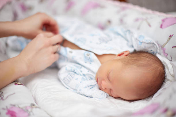istock Mother dressing her cute hewborn baby daughter 1396832916