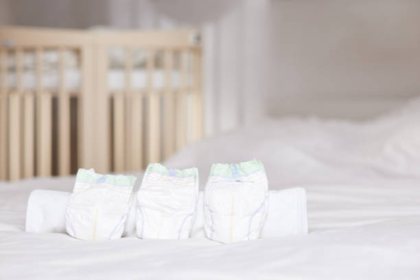 Set of disposable soft new baby diapers Set of disposable soft new baby diapers on background of baby bed bed of hay stock pictures, royalty-free photos & images