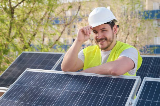 istock Solar panels technician looking at camera after installing photovoltaic station. 1396834405