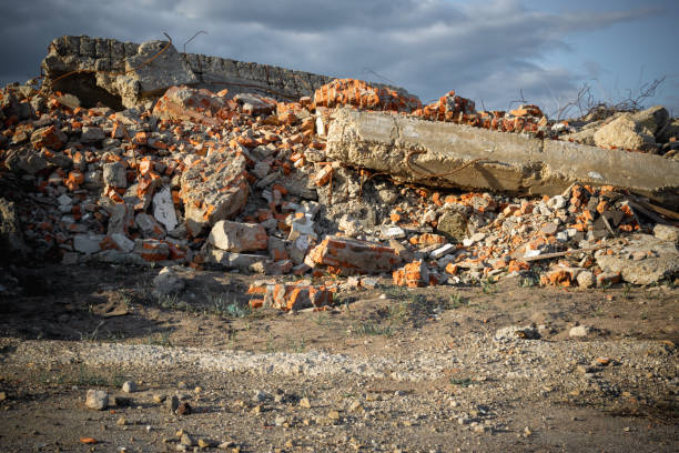 The wreckage of a destroyed building against a cloudy sky.