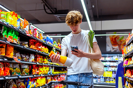 Young man scanning drink in grocery store