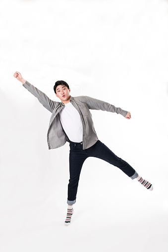 A young man is jumping excitedly in a funny pose