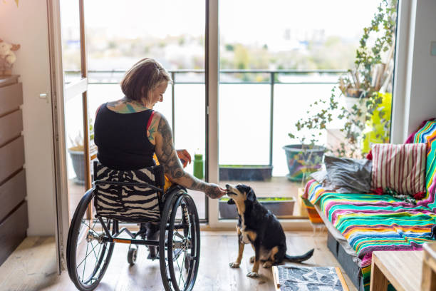 Young woman with disability with her dog at home stock photo