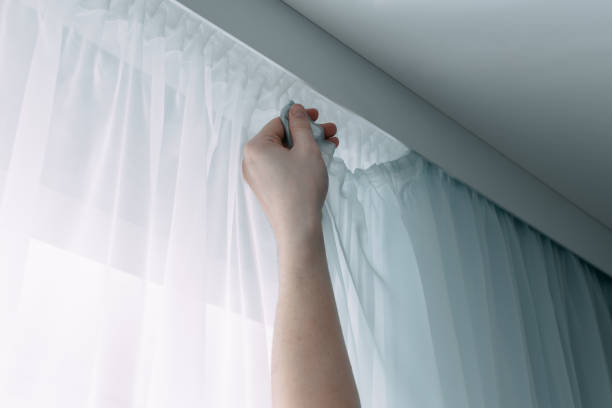 istock Close up of man hands hanging curtain on ceiling ledge. Interior decor element. 1396838927