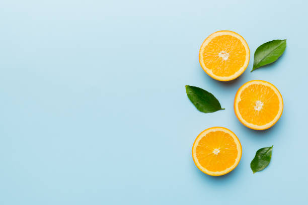istock fresh Fruit orange slices on colored background. Top view. Copy Space. creative summer concept. Half of citrus in minimal flat lay with copy space 1396840396