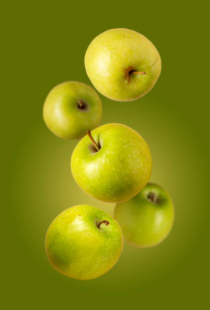 istock green apples fly on a green background, creative photo 1396840701