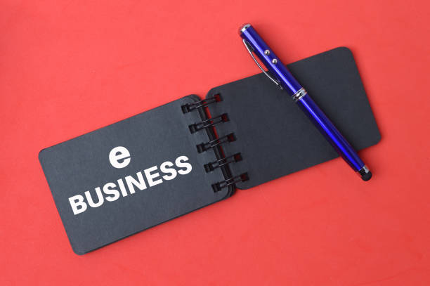 istock Pen and notebook written with text E-Business over red background. 1396841473