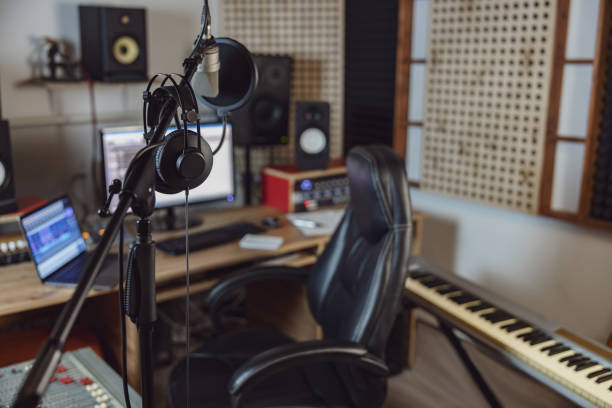 istock Microphone and headphones in blurred sound engineer office for broadcasting and music rehearsal space. Recording studio 1396841587