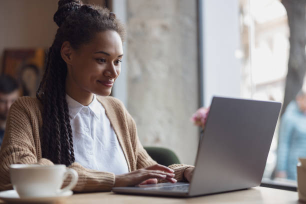 istock Adorable African woman student types text on laptop keyboard, works, studies, doing research or prepares for exam online 1396841615