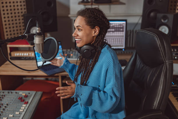 istock Multiethnic pleasant radio presenter records podcast using headphones and talking into microphone in a recording studio 1396841749