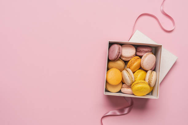 istock Macaroons almond biscuits in  gift box on pink pastel background 1396844671