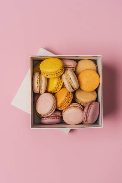 istock Macaroons almond biscuits in  gift box on pink pastel background 1396844675