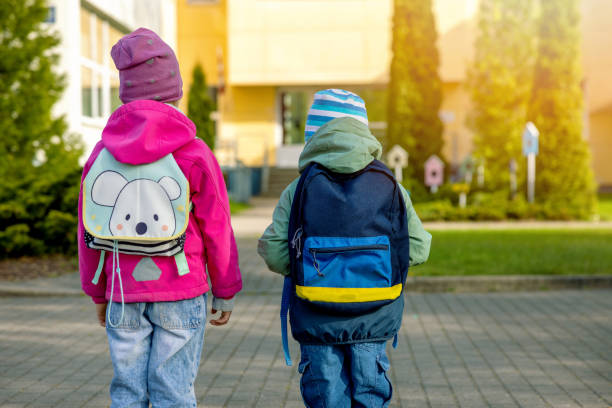 istock children with backpacks going to school in the morning. back view 1396846046