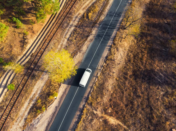 istock Aerial top view white modern delivery small shipment cargo courier van moving fast on motorway road city urban suburb. Busines distribution and logistics express service. Mini bus driving highway day 1396846130