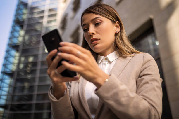 istock Serious looking businesswoman standing alone using phone 1396849303