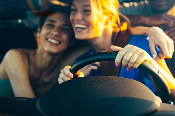 istock Laughing young girlfriends driving together in a car 1396849443