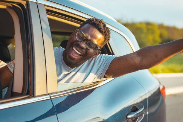 istock Smiling man looking outside from car window 1396849564