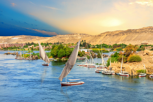 Sailboats in front of the hills of the Nile in Aswan, Egypt.