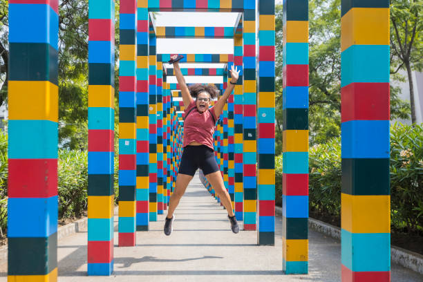 Woman jumps between colorful installations in Mexico City, Mexico, stock photo