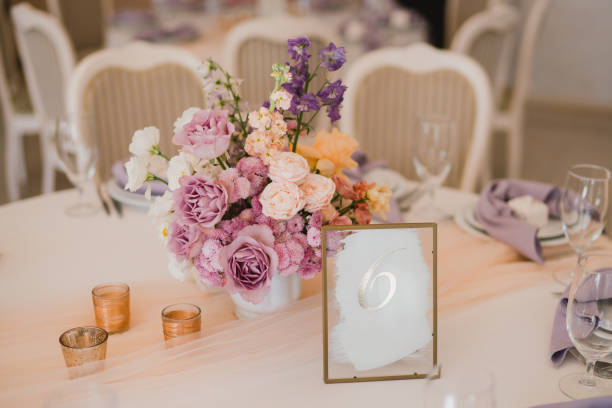 istock Table setting at the wedding reception. Floral compositions with beautiful flowers and greenery, candles, laying and plates on a decorated table. 1396855977