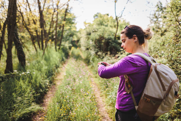 istock Overweight woman using smart watch while walking in the woods 1396856023