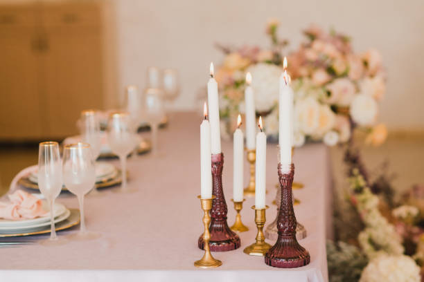 istock Table setting at the wedding reception. Floral compositions with beautiful flowers and greenery, candles, laying and plates on a decorated table. 1396856119