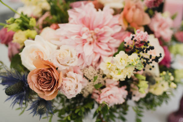 istock Table setting at the wedding reception. Floral compositions with beautiful flowers and greenery, candles, laying and plates on a decorated table. 1396858230