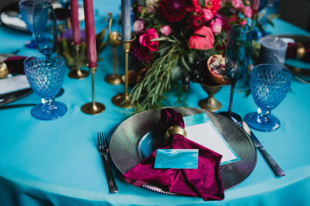istock Table setting at the wedding reception. Floral compositions with beautiful flowers and greenery, candles, laying and plates on a decorated table. 1396859176