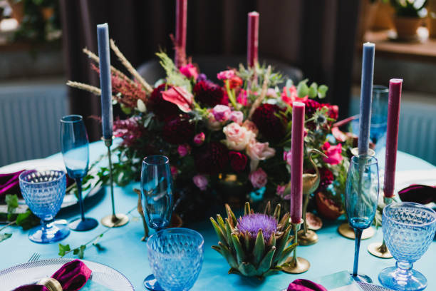 istock Table setting at the wedding reception. Floral compositions with beautiful flowers and greenery, candles, laying and plates on a decorated table. 1396859244