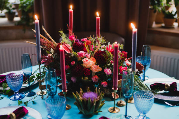 istock Table setting at the wedding reception. Floral compositions with beautiful flowers and greenery, candles, laying and plates on a decorated table. 1396859451