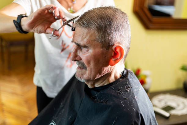 istock Senior man getting hairstyle in nursing home. 1396859622