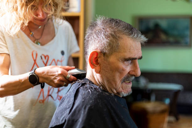 istock Senior man getting hairstyle in nursing home. 1396859628