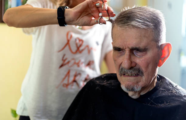 istock Senior man getting hairstyle in nursing home. 1396859649