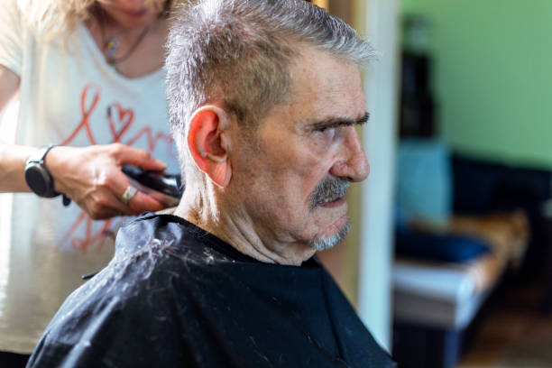 istock Senior man getting hairstyle in nursing home. 1396859656
