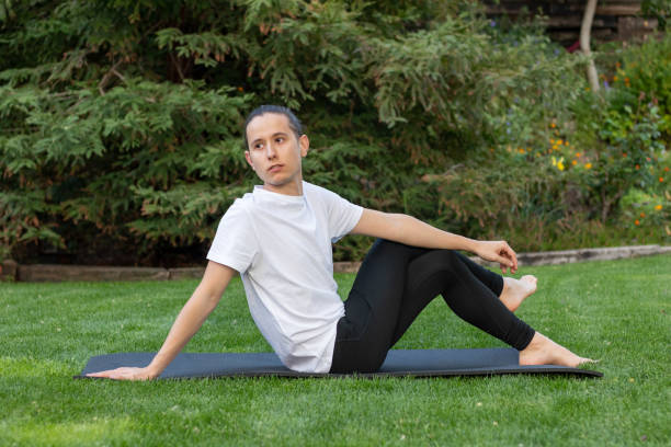 istock Young and beautiful man stretching after having done yoga exercise looking to the side on a mat in the garden 1396860270