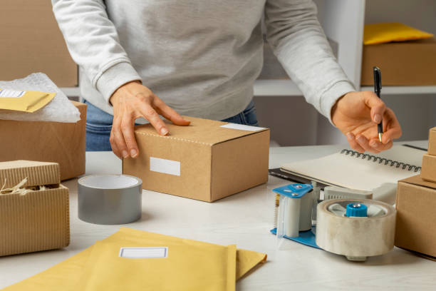 istock Warehouse worker at the workplace prepares the goods in a box for mailing. 1396860393
