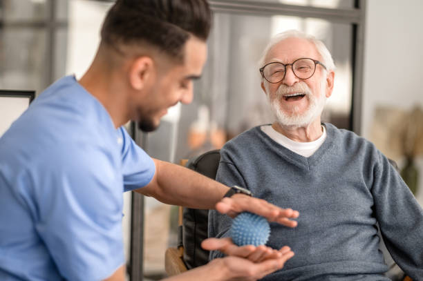 Patient having his hand massaged with a spiky massage ball stock photo