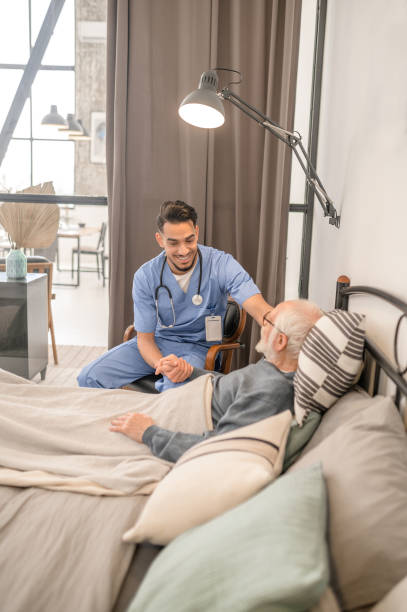 istock Doctor cheering up an ill patient during his home visit 1396861256