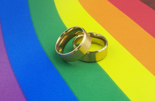 Anillos de boda de oro en la bandera del orgullo LGBT. photo