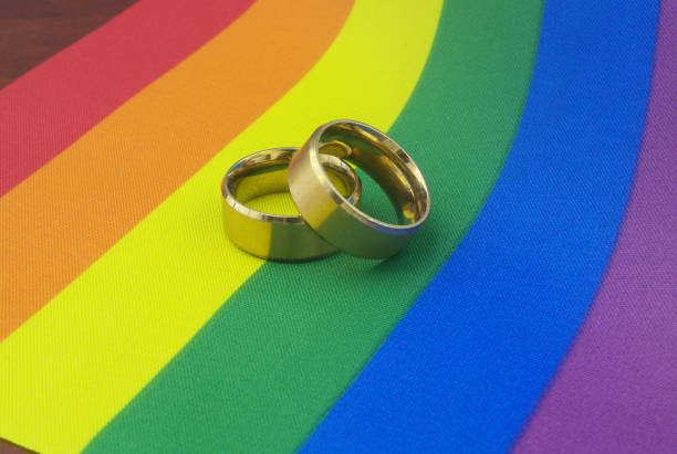 istock Gold wedding rings on LGBT pride flag. 1396863908