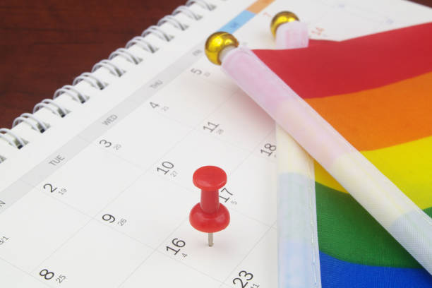 istock Red push pin on calendar page and LGBT flags. 1396864608