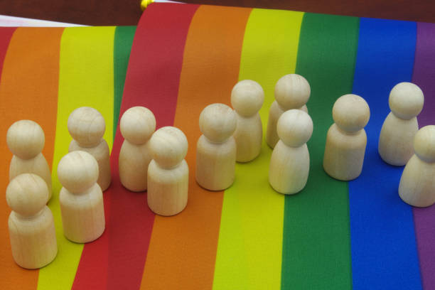 istock Wooden people figures in a row on LGBT pride flag. 1396864759